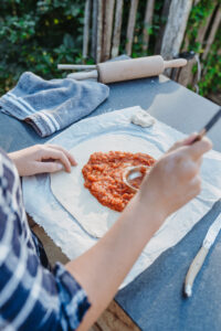 Binnenplaats La-Bastide pizzaoven saus op pizza