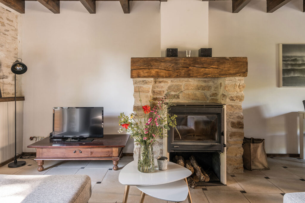 Vakantiehuis Bretagne La-Bastide woonkamer haardschouw met houtkachel en televisie