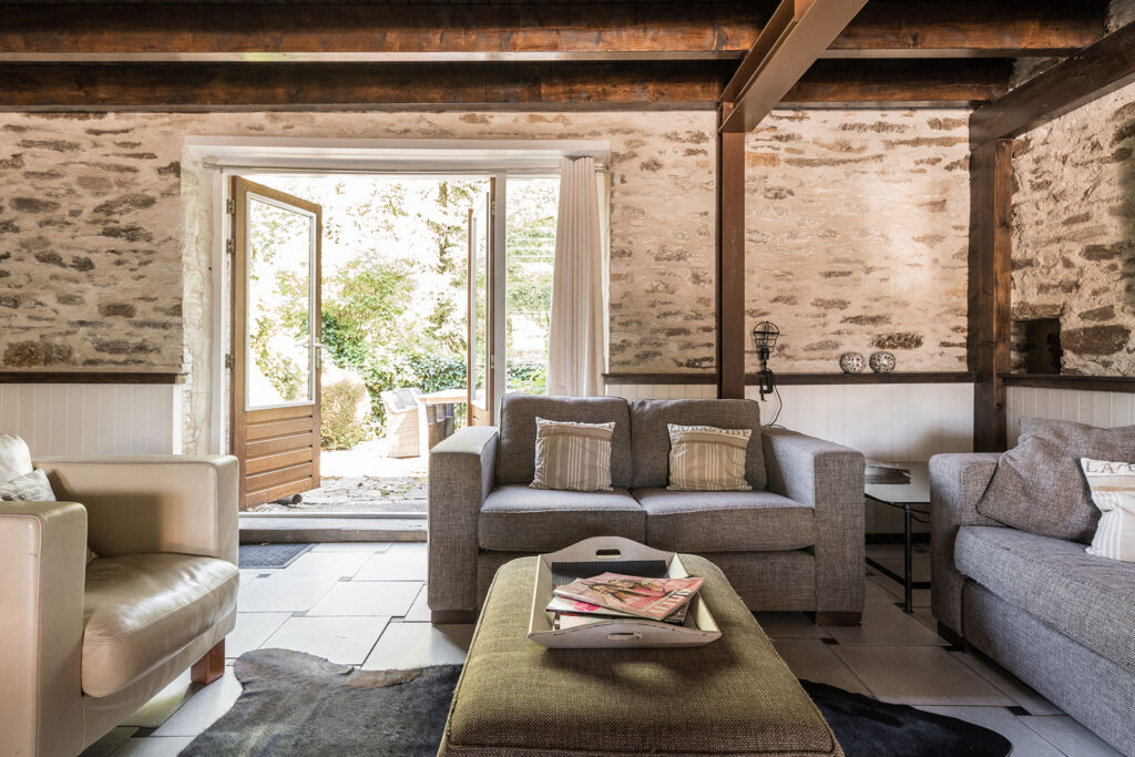 Vakantiehuis Limousin La-Bastide woonkamer zithoek met openslaande deuren naar het achter terras