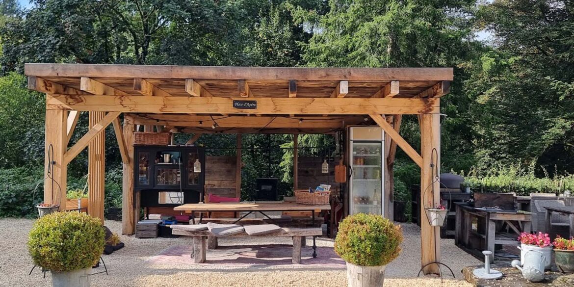 Binnenplaats met eettafels grillplaat en pizzaoven op vakantiedomein La-Bastide in de Haute-Vienne