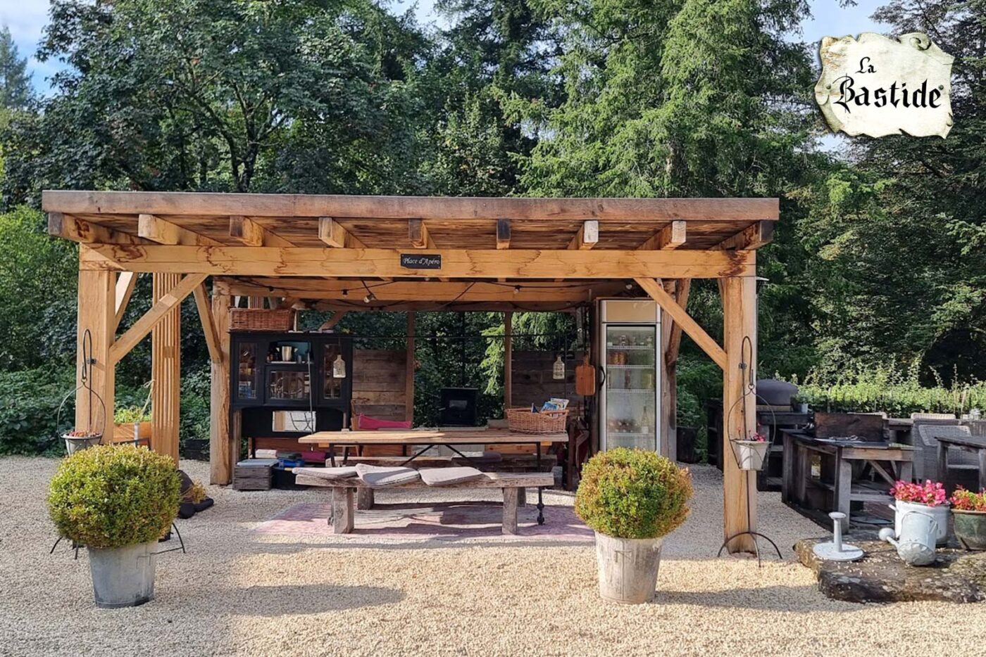 Binnenplaats met eettafels grillplaat en pizzaoven op vakantiedomein La-Bastide in de Haute-Vienne